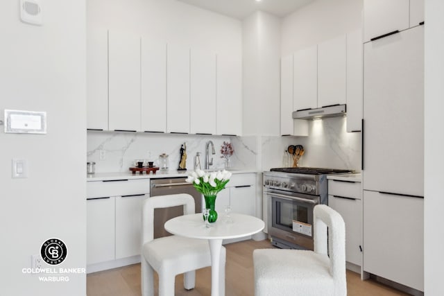 kitchen with backsplash, stainless steel appliances, and white cabinets