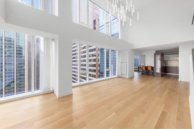 unfurnished living room with hardwood / wood-style flooring and a chandelier