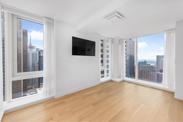 unfurnished living room with plenty of natural light, wood finished floors, and baseboards