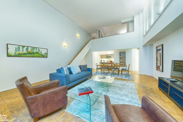 living room with parquet flooring and a towering ceiling