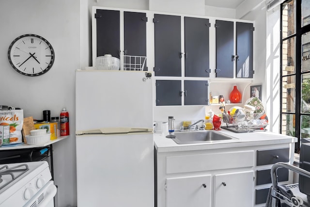 kitchen with white appliances, light countertops, and a sink