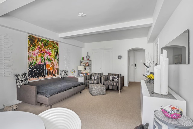 living room featuring light carpet, arched walkways, and beam ceiling