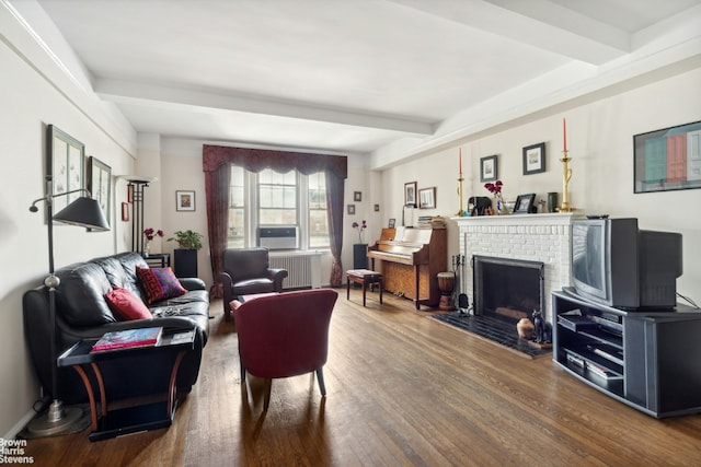 living room featuring radiator, a brick fireplace, beamed ceiling, and hardwood / wood-style floors