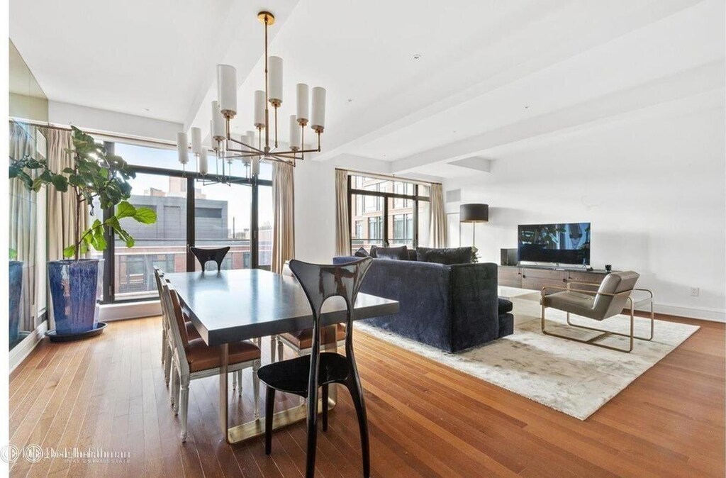 dining room featuring wood finished floors, an inviting chandelier, beam ceiling, and a wealth of natural light