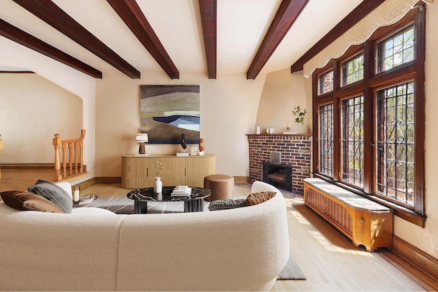 67-31 Ingram St, New York City, NY 11375 - living room with beamed ceiling, a brick fireplace, radiator heating unit, and light hardwood / wood-style flooring