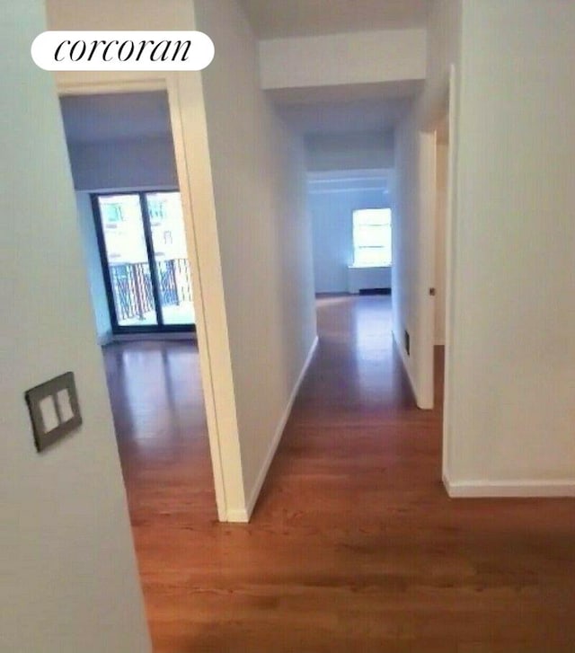 hallway with baseboards and wood finished floors