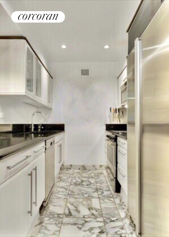 kitchen with white cabinets, marble finish floor, visible vents, and stainless steel appliances