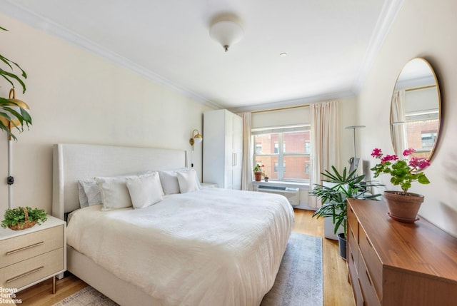 bedroom featuring light wood-type flooring and ornamental molding