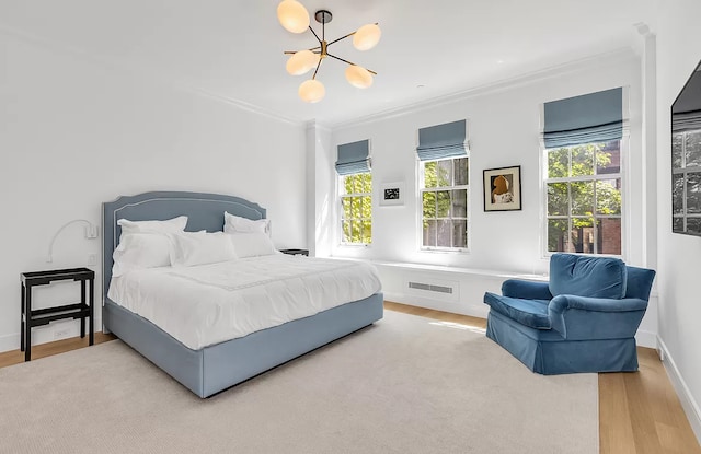 bedroom with ornamental molding, multiple windows, and wood finished floors