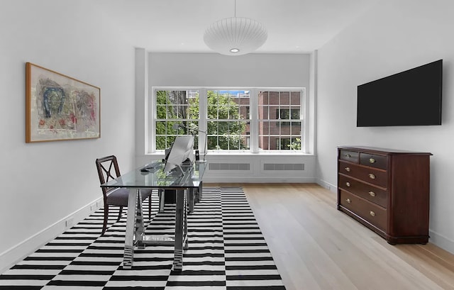 dining room featuring light wood-type flooring and baseboards