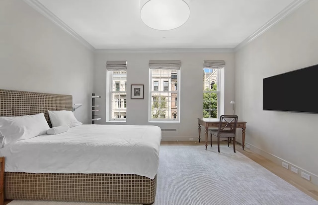 bedroom featuring crown molding, baseboards, and wood finished floors