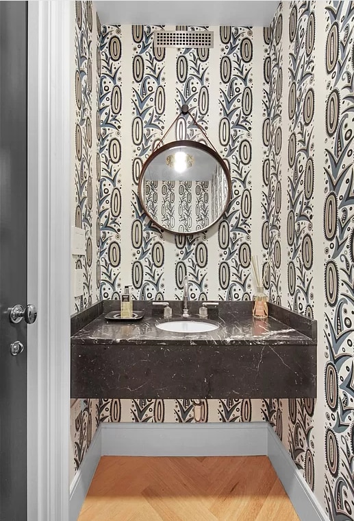 bathroom with baseboards, a sink, and wallpapered walls