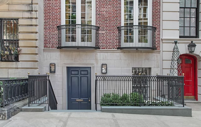 view of exterior entry featuring stone siding and brick siding