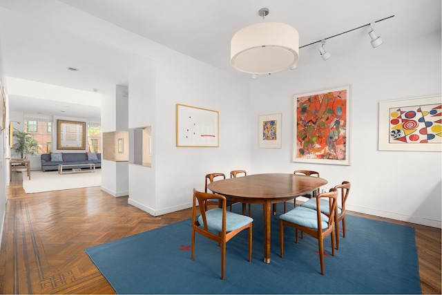 dining space with rail lighting and baseboards
