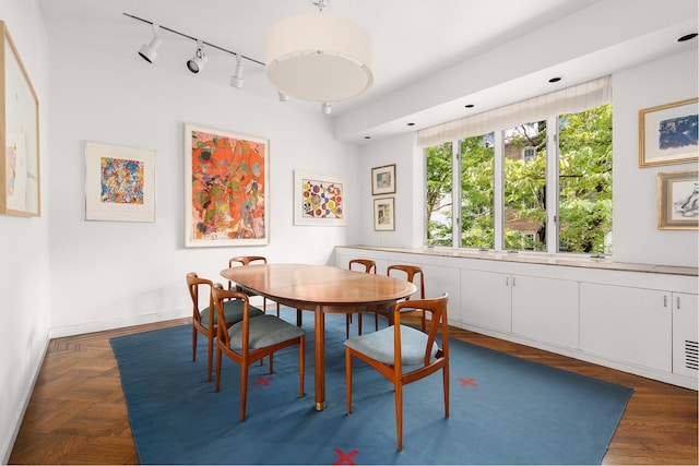 dining room with rail lighting and baseboards