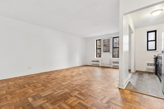 unfurnished living room with baseboards and radiator