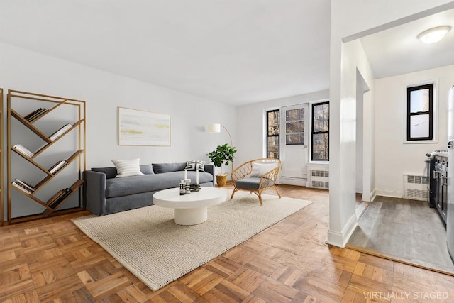 living room featuring parquet flooring and radiator heating unit