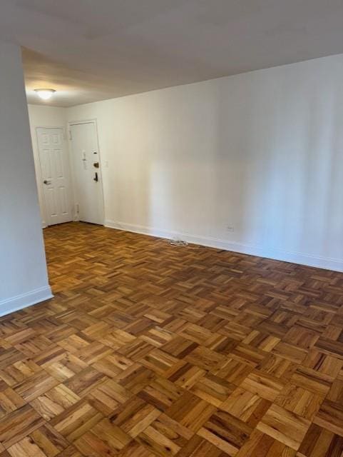 spare room with dark parquet flooring