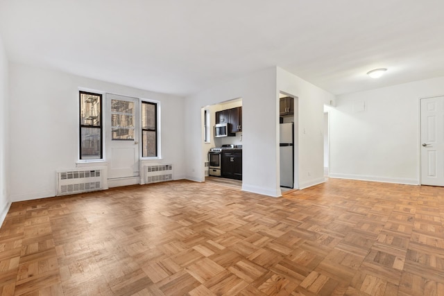 unfurnished living room with radiator heating unit and baseboards