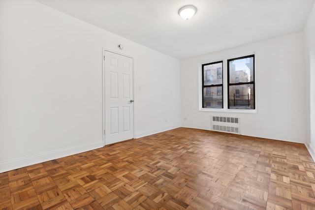 empty room with radiator and baseboards