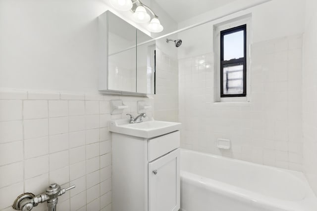 bathroom featuring bathtub / shower combination, tile walls, and vanity