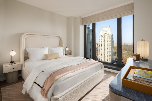 bedroom featuring a view of city and wood finished floors