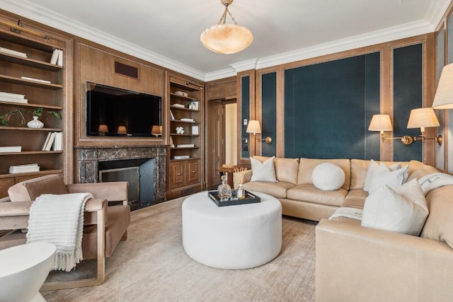 living room with ornamental molding, a high end fireplace, and built in shelves