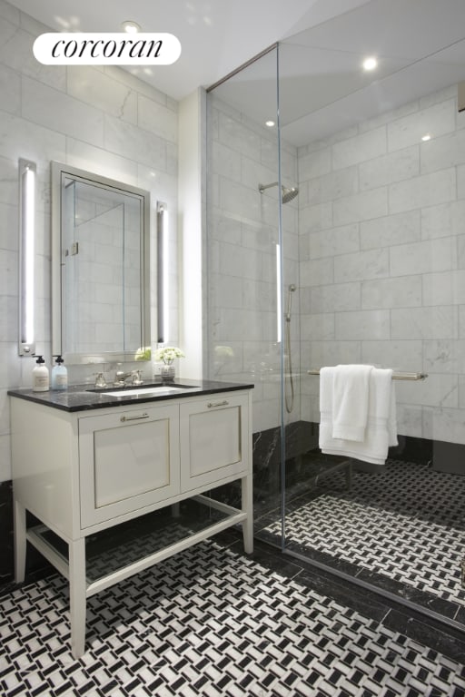 bathroom with vanity, tile walls, and walk in shower