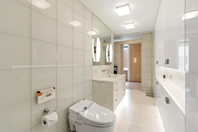 bathroom featuring toilet, tile patterned flooring, tile walls, and vanity