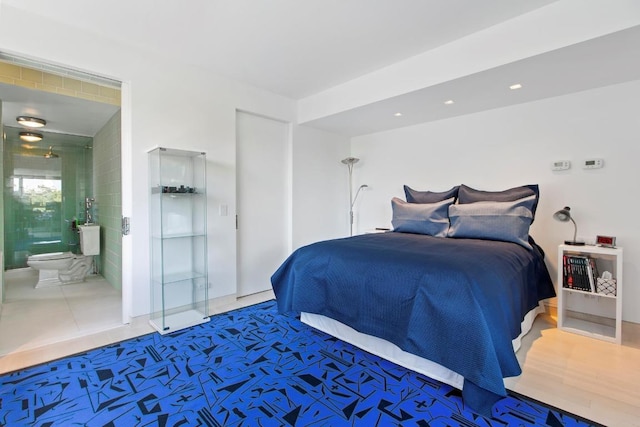 bedroom with connected bathroom and hardwood / wood-style flooring