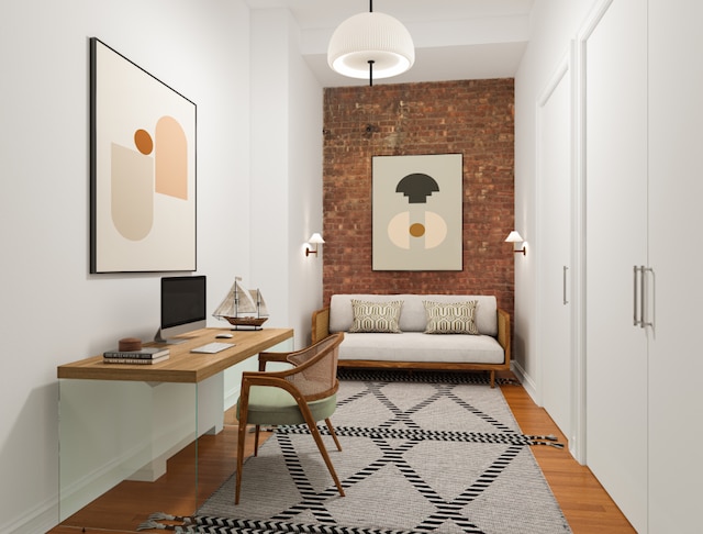 home office featuring brick wall and light hardwood / wood-style floors