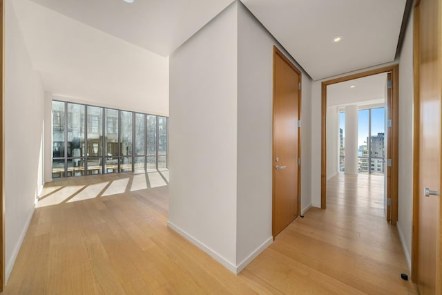 corridor featuring recessed lighting, light wood-style floors, and baseboards