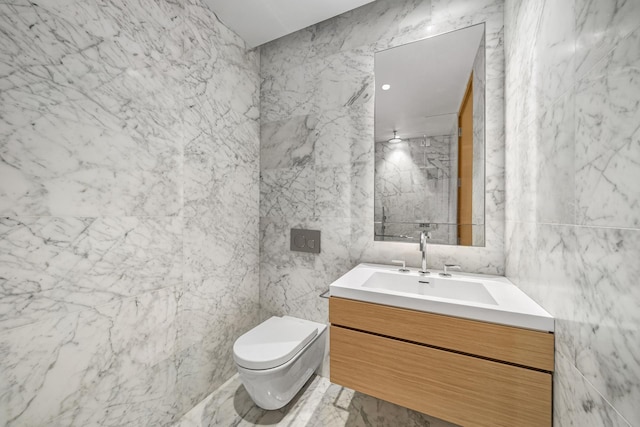 full bath featuring walk in shower, toilet, tile walls, vanity, and marble finish floor