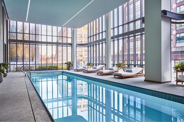 community pool featuring a patio area and glass enclosure