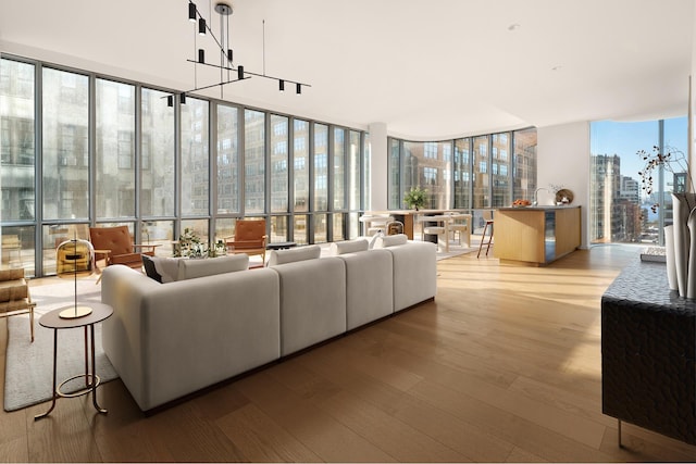living area with wood finished floors, a view of city, and expansive windows