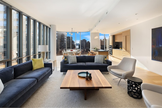 interior space featuring light wood-style floors, baseboards, floor to ceiling windows, and a city view