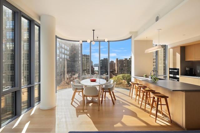 sunroom / solarium featuring a view of city and a sink