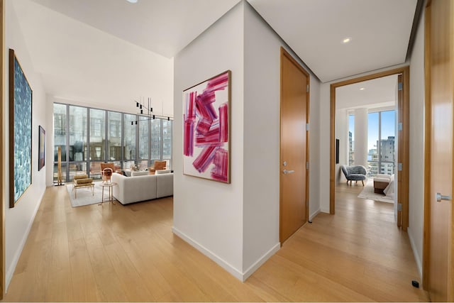 corridor with recessed lighting, light wood-type flooring, and baseboards