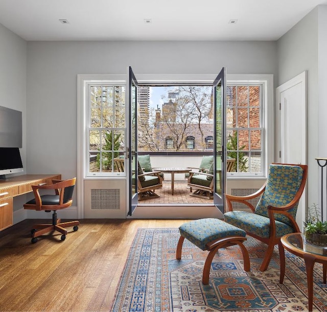 living area featuring radiator heating unit and light hardwood / wood-style flooring