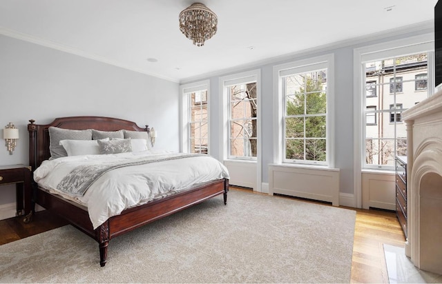 bedroom with multiple windows, ornamental molding, a notable chandelier, and light hardwood / wood-style floors