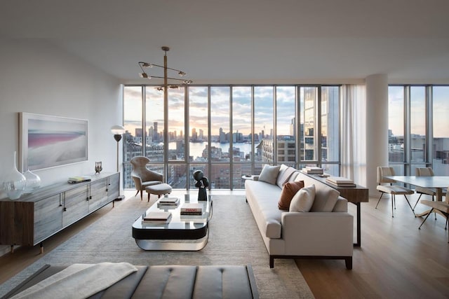 living room with light wood-type flooring, a chandelier, and a wall of windows