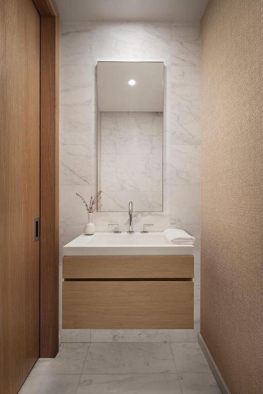 bathroom with vanity and tile walls