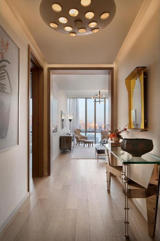 hallway featuring a wall of windows, ornamental molding, a chandelier, and light wood-type flooring