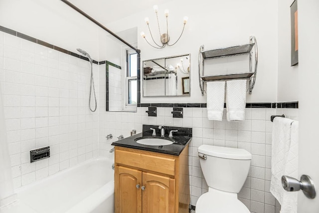 full bathroom with toilet, vanity, tile walls, a notable chandelier, and tiled shower / bath