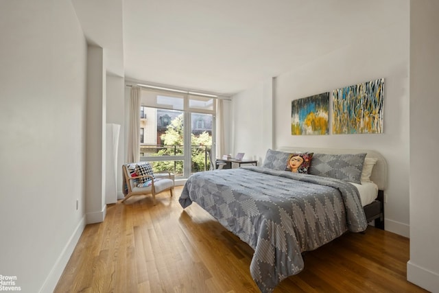 bedroom featuring hardwood / wood-style floors and a wall of windows