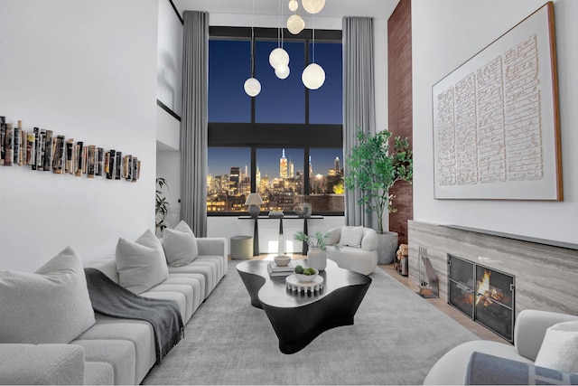 living area with a glass covered fireplace, a city view, and a towering ceiling