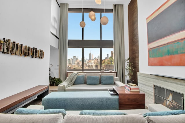 living area featuring a city view, a towering ceiling, and a high end fireplace