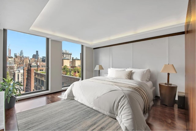 bedroom featuring floor to ceiling windows and dark hardwood / wood-style floors