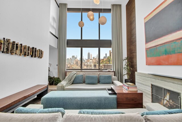 living room with a view of city, a high ceiling, and a high end fireplace