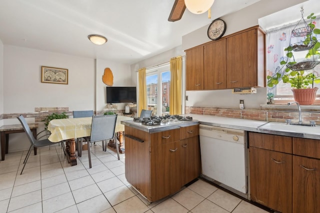 kitchen with dishwasher, brown cabinets, a peninsula, gas cooktop, and a sink